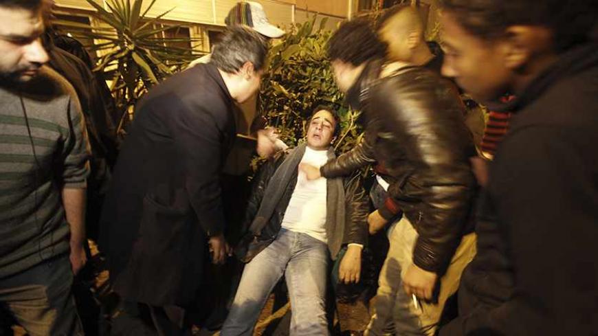 An injured journalist is surrounded by other journalists after the Al Wafd headquarters was attacked by Islamists in Cairo December 15, 2012. Islamists attacked the opposition Wafd party's newspaper offices in central Cairo with petrol bombs and birdshot on Saturday, security sources said. The violence flared as Egyptians voted in a referendum on a new constitution intended to pull the country out a growing political crisis. Two people were injured and firefighters said they had put out the flames, a Reuter