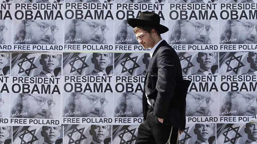 An ultra-Orthodox Jewish man walks past posters calling for U.S. President Barack Obama to free Jonathan Pollard from a U.S. prison, in Jerusalem March 20, 2013. Obama arrives in Israel on Wednesday without any new peace initiative to offer disillusioned Palestinians and facing deep Israeli doubts over his pledge to prevent a nuclear-armed Iran. Pollard, a former U.S. Navy intelligence analyst, has been serving a life sentence in the United States since he was caught spying for Israel in the 1980s. REUTERS/