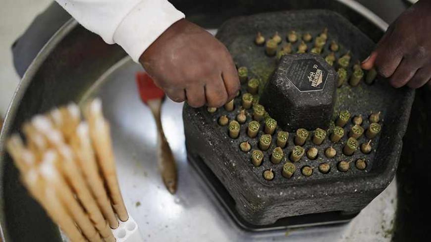 A worker rolls the tops of newly prepared cigarettes filled with marijuana at a plantation near the northern town of Nazareth May 28, 2013. Marijuana is an illegal drug in Israel. Medicinal use of it was first permitted in 1993, according to the health ministry. Today cannabis is used in Israel to treat 11,000 people suffering from illnesses such as cancer, Parkinson's, multiple sclerosis, Crohn's disease and post traumatic stress disorder, according to Israel's health ministry. REUTERS/Amir Cohen (ISRAEL -