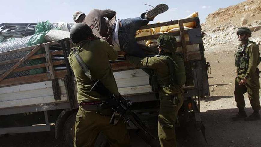 Israeli soldiers pull a Palestinian off a truck loaded with items European diplomats wanted to deliver to locals in the West Bank herding community of Khirbet al-Makhul, in the Jordan Valley September 20, 2013. Israeli soldiers manhandled European diplomats on Friday and seized the truck full of tents and emergency aid they had been trying to deliver to Palestinians whose homes were demolished earlier this week. REUTERS/Abed Omar Qusini (WEST BANK - Tags: POLITICS CIVIL UNREST MILITARY) - RTX13SH3