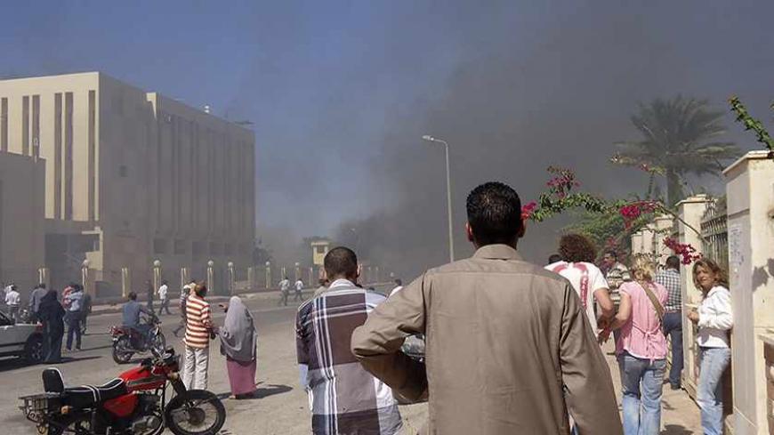 Residents and tourists watch as smoke raises near a state security building after a blast in South Sinai October 7, 2013. Medical sources said three were killed and 48 injured in the blast near the state security building in South Sinai. A witness said it was caused by a car bomb.  REUTERS/Stringer (EGYPT - Tags: POLITICS CIVIL UNREST) - RTX142T0