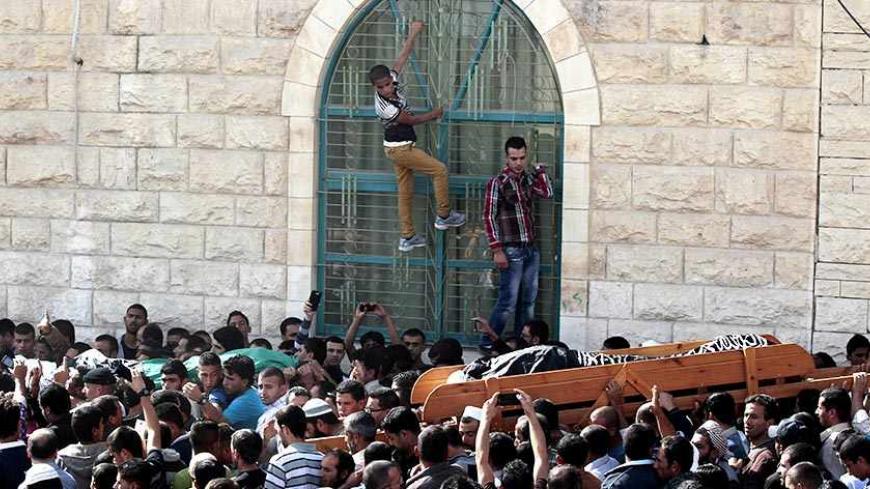 Boys hold onto window bars as the bodies of Palestinian Moussa Makhamra (R) and Khalid al-Najjar are carried during their funeral in the West Bank village of Yatta, near Hebron November 27, 2013. Israeli security officials said their forces killed three Palestinian militants, including Makhamra and al-Najjar, on Tuesday who were part of an al Qaeda-linked network in the West Bank. REUTERS/Ammar Awad (WEST BANK - Tags: POLITICS CIVIL UNREST) - RTX15UU9