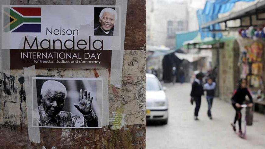 Posters depicting former South African President Nelson Mandela are seen on a wall in Jerusalem's old city December 7, 2013. South African anti-apartheid hero Mandela died aged 95 at his Johannesburg home on December 5, 2013 after a prolonged lung infection.    REUTERS/Ammar Awad (JERUSALEM  - Tags: POLITICS OBITUARY) - RTX168F9