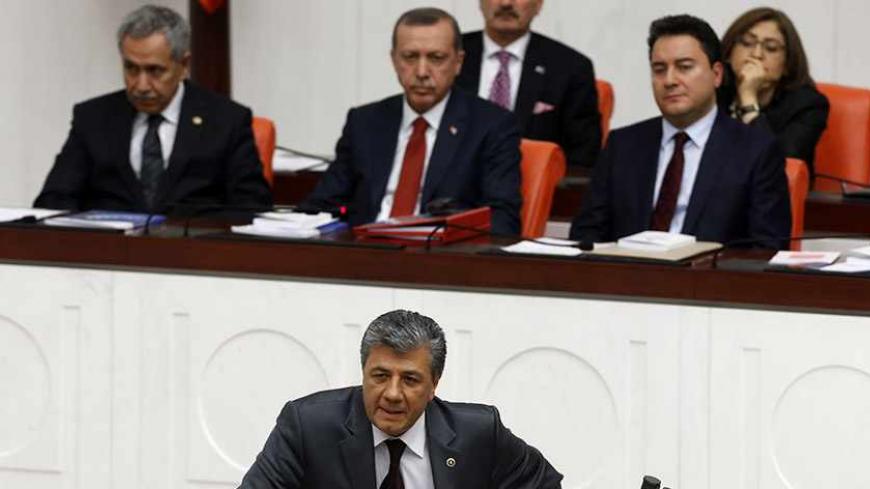 Turkish journalist and Republican People's Party (CHP) MP Mustafa Balbay addresses the members of the Turkish Parliament during a debate on a draft budget as Turkey's Prime Minister Tayyip Erdogan (rear C) and his ministers listen in Ankara December 10, 2013. Turkish journalist Mustafa Balbay took his oath of office as a member of parliament on Tuesday after his release from nearly five years in prison on security charges, raising hope among other jailed deputies that they could follow in his footsteps. REU