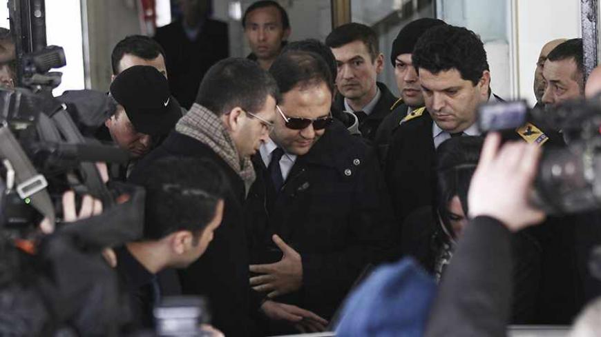 Baris Guler (C in sunglasses), son of Turkey's Interior Minister Muammer Guler, is escorted by plainclothes police officers as he leaves a medical check-up in Istanbul December 16, 2013. Turkish police detained the sons of three cabinet ministers and several well-known businessmen as part of investigations into alleged corruption on Tuesday, state officials said, in a blow to Prime Minister Tayyip Erdogan months ahead of elections. Police carried out dawn raids in the main commercial city Istanbul, detainin