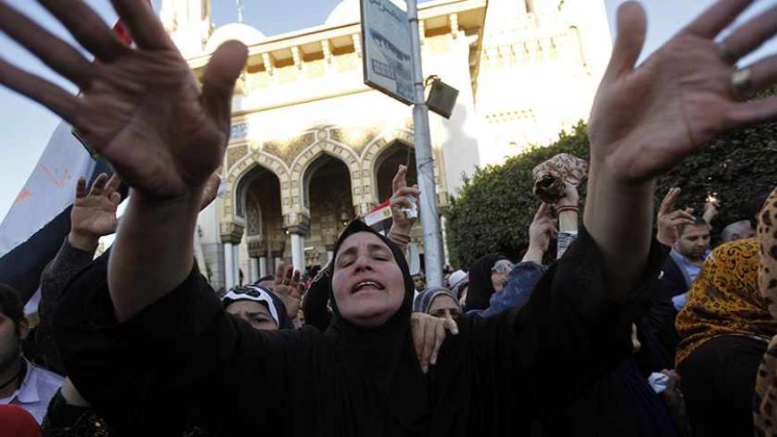 A woman cries during a funeral service for policemen and people killed in a car bomb explosion, near Al Naser Mosque in Egypt's Nile Delta city of Mansoura in Dakahlyia province, about 120 km (75 miles) northeast of Cairo, December 24, 2013. The car bomb tore through a police compound in Mansoura on Tuesday, killing 13 people and wounding more than 130, security officials said, in one of the deadliest attacks since the army deposed Islamist President Mohamed Mursi in July. The army-backed government vowed t