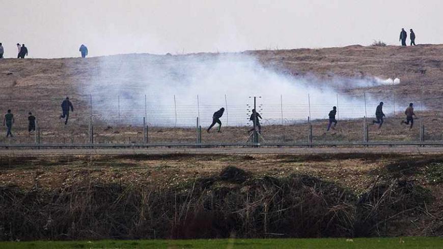 Palestinian demonstrators protest near the Israeli border fence with Gaza as the Israeli army shoots tear gas, December 27, 2013. REUTERS/Amir Cohen (ISRAEL - Tags: CIVIL UNREST POLITICS) - RTX16V3B