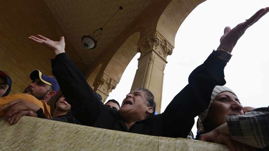 A woman reacts during a mass funeral for former Lebanese minister Mohamad Chatah, who was killed in a bomb blast on Friday, at Al-Amin mosque in Martyrs' Square, downtown Beirut, December 29, 2013.  Chatah, who opposed Syrian President Bashar al-Assad, was killed in the attack which one of his political allies blamed on Lebanon's Shi'ite Hezbollah militia. REUTERS/Jamal Saidi (LEBANON - Tags: POLITICS CIVIL UNREST OBITUARY) - RTX16WB3