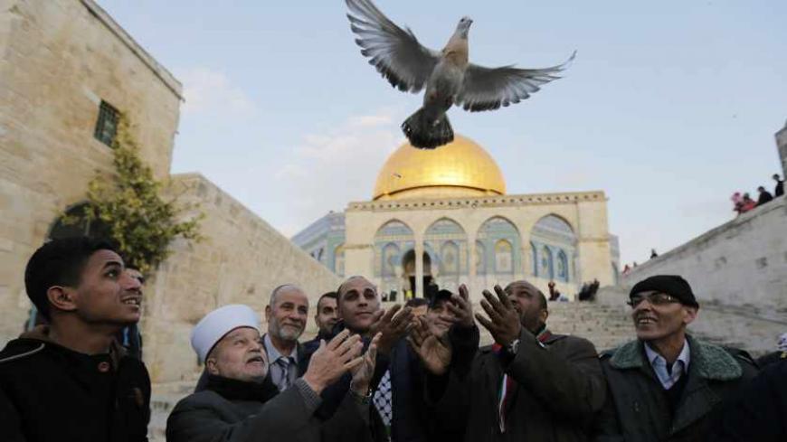 Ahmad Khalaf  (4th R) looks on as a religious leader together with others release a dove outside the al-Aqsa mosque the day after he was released from an Israeli prison, in Jerusalem's old city December 31, 2013. Israel freed 26 Palestinian prisoners, on Tuesday, days before U.S. Secretary of State John Kerry was due back in the Middle East to press the two sides to agree a framework peace deal.REUTERS/Ammar Awad (JERUSALEM - Tags: POLITICS) - RTX16Y77