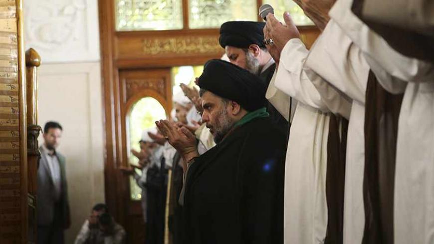 Iraqi Shi'ite radical cleric Muqtada al-Sadr (C) takes part in Friday prayers at the Kufa mosque near Najaf, 160 km (100 miles) south of Baghdad May 10, 2013. REUTERS/Ahmad Mousa (IRAQ - Tags: RELIGION) - RTXZHC5