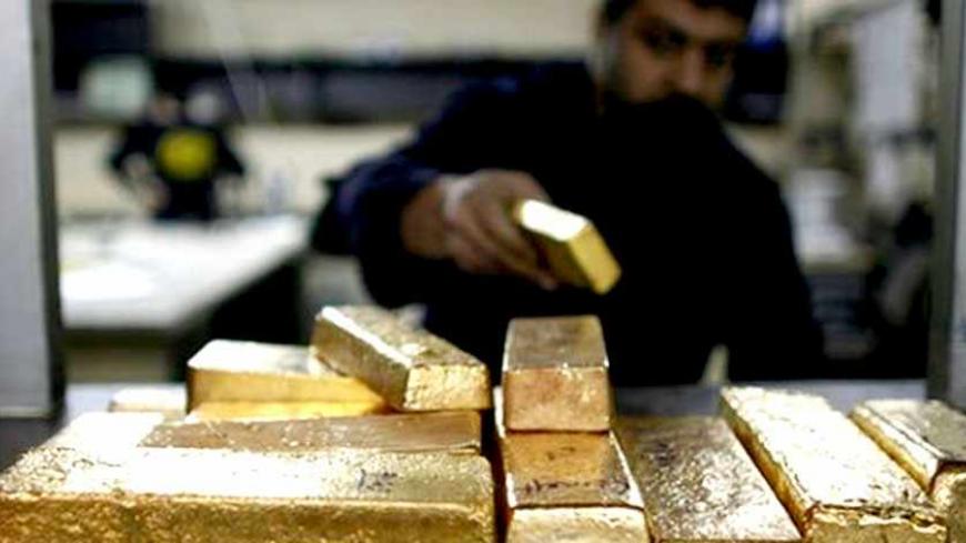 A labourer works on the gold bars which are going to be melted in a smelter at a plant of gold refiner in Istanbul February 27, 2009. Gold extended gains to session highs in Europe on Friday as risk aversion spurred by worse-than- expected U.S. GDP data lifted the metal from the two-week lows it hit earlier in the day. REUTERS/Osman Orsal   (TURKEY)