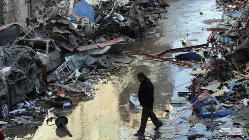 A man walks near debris after an explosion near a security building in Egypt's Nile Delta city of Mansoura in Dakahlyia province, about 120 km (75 miles) northeast of Cairo December 24, 2013. Egypt's Muslim Brotherhood condemned the bomb attack on the security compound in the Dakahlyia which killed 12 people and wounded more than 100 early on Tuesday, a month before a vote on a new constitution key to transition from military-backed rule. REUTERS/Mohamed Abd El Ghany (EGYPT - Tags: POLITICS CIVIL UNREST DIS