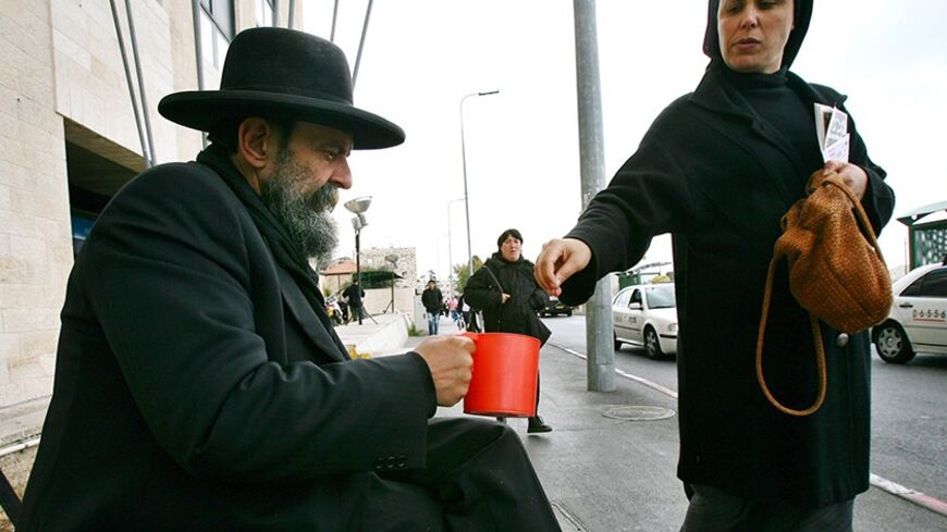 An Ultra-Orthodox Jewish man begs for change as he sits on a sidewalk in Jerusalem March 26, 2006. A growing number of Israelis live beneath the poverty line, many of them ultra-Orthodox Jews, immigrants and elderly. Poverty is a prominent issue in Israel's campaign for a March 28 parliamentary election. Picture taken march 26, 2006.   REUTERS/Ronen Zvulun - RTR17NNS