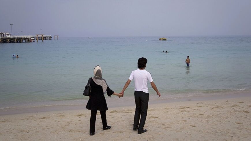EDITORS' NOTE: Reuters and other foreign media are subject to Iranian restrictions on leaving the office to report, film or take pictures in Tehran.
A couple holds hands while walking on the beach of Kish Island, 1,250 kilometers (777 miles) south of Tehran April 26, 2011 . REUTERS/Caren Firouz (IRAN - Tags: SOCIETY TRAVEL) - RTR2LMWP
