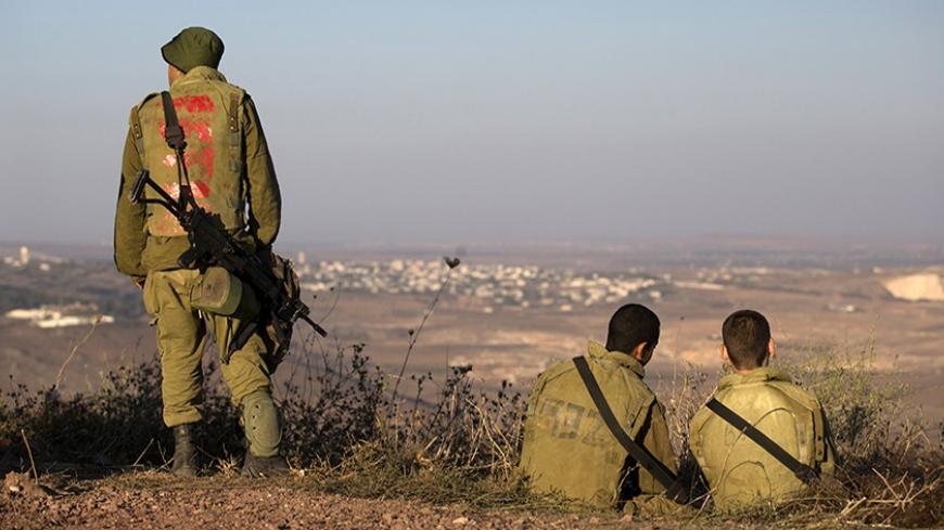 Israeli soldiers look across the border to Syria in the Israeli-occupied Golan Heights August 30, 2013. Israel ordered a small-scale mobilisation of reservists on Wednesday and strengthened its missile defences as precautions against possible Syrian attack should Western powers carry out threatened strikes on Syria. REUTERS/Ronen Zvulun (MILITARY POLITICS) - RTX131QH