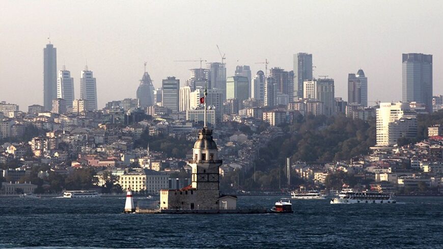 Turkey's historical Maiden's Tower is seen on the Bosphorus with the city's skyscrapers in the background, in Istanbul August 28, 2013. Along the picturesque Bosphorus Straits dividing Europe and Asia, Istanbul is undergoing a transformation which should fill Turkey with confidence in its bid to become the first Muslim country to stage the Olympics in 2020. Overlooking the waterway, mechanical diggers are tearing down Besiktas' Inonu Stadium to make way for a state-of-the-art facility earmarked to stage rug