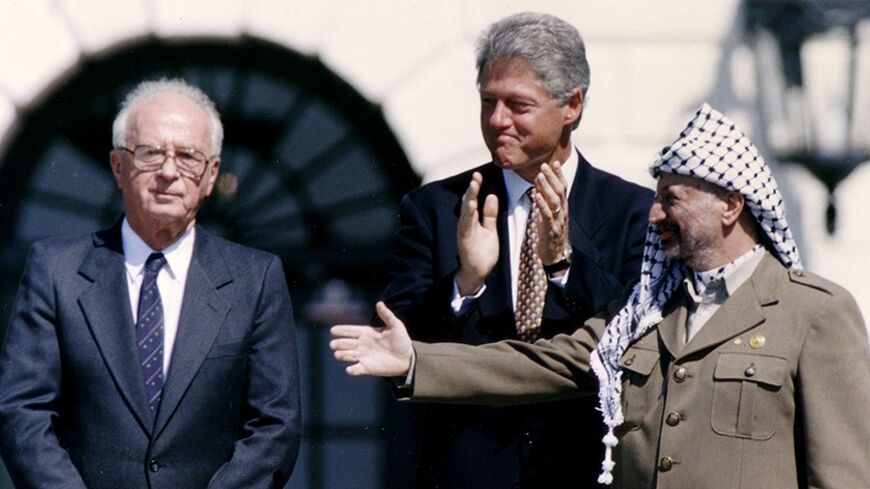PLO Chairman Yasser Arafat (R) gestures to Israeli Prime Minister Yitzhak Rabin (L), as U.S. President Bill Clinton stands between them, following their handshake after the signing of the Israeli-PLO peace accord, at the White House in Washington September 13, 1993. REUTERS/Gary Hershorn (UNITED STATES - Tags: POLITICS) - RTX13K5G