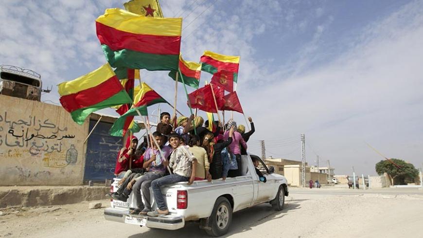 People sit in the back of a truck as they celebrate what they said was the liberation of villages from Islamist rebels near the city of Ras al-Ain in the province of Hasakah, after capturing it from Islamist rebels November 6, 2013. Redur Xelil, spokesman for the armed wing of the Syrian Kurdish Democratic Union Party (PYD), said Kurdish militias had seized the city of Ras al-Ain and all its surrounding villages. Syrian Kurdish fighters have captured more territory from Islamist rebels in northeastern Syria
