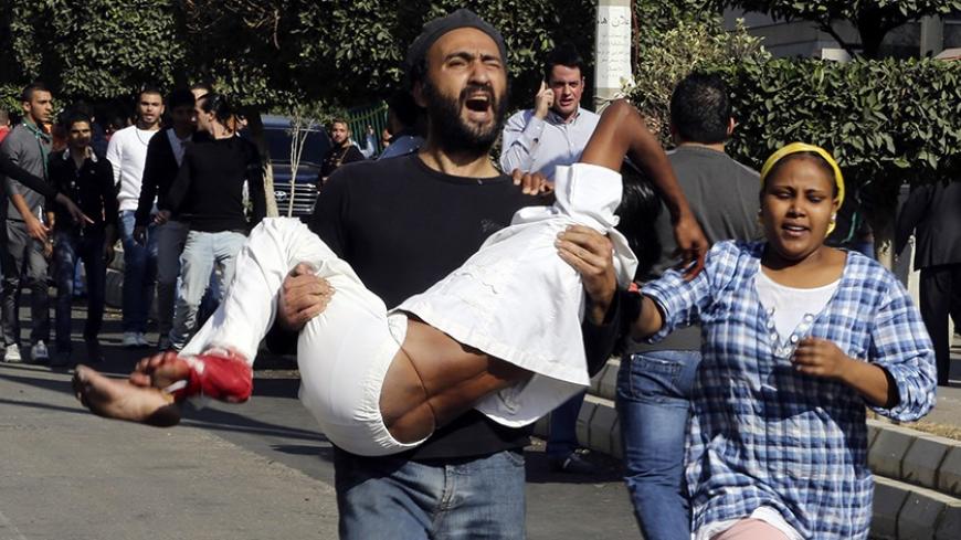 A man carrying a wounded woman runs from the site of explosions near the Iranian embassy in Beirut November 19, 2013. Two explosions targeting the Iranian embassy hit the Lebanese capital Beirut on Tuesday killing at least 23 people, including Iranian cultural attache Ebrahim Ansari, and damaging buildings around the embassy compound, Lebanese sources said. REUTERS/Issam Kobeisy     (LEBANON - Tags: POLITICS DISASTER) - RTX15JSM