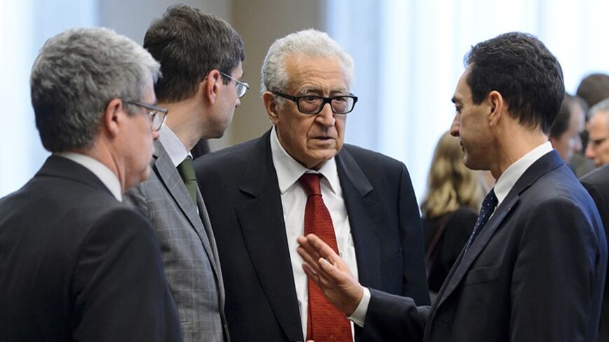 Lakhdar Brahimi (C), the U.N. envoy on Syria, speaks with members of the French delegation prior to a meeting at the United Nations offices in Geneva December 20, 2013. REUTERS/Fabrice Coffrini/Pool (SWITZERLAND - Tags: POLITICS) - RTX16PMV