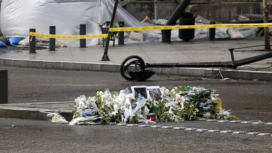 Flowers are placed next to the picture of Mohammed Chaar, who was killed along with Lebanon's former Finance Minister Mohamad Chatah in a bomb blast on Friday, at the site of the explosion in Beirut December 30, 2013. Friday's attack on Chatah, a Sunni who was a vocal critic of Syrian President Bashar al-Assad and his Lebanese ally Hezbollah, has once again stoked sectarian enmities exacerbated by the spillover of Syria's conflict. REUTERS/Mohamed Azakir (LEBANON - Tags: POLITICS CIVIL UNREST) - RTX16XA2