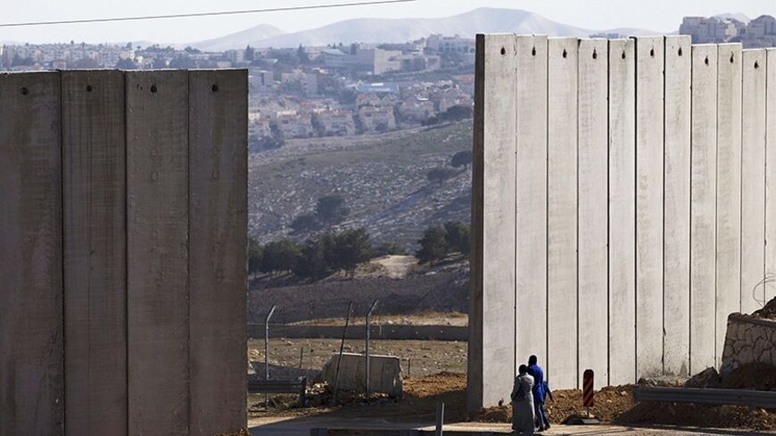Palestinians walk near an opening in Israel's controversial barrier in the East Jerusalem neighbourhood of A-tur January 3, 2014. Israeli Prime Minister Benjamin Netanyahu offered a gloomy assessment of peace prospects with the Palestinians on Thursday as U.S. Secretary of State John Kerry began his 10th visit to the region in pursuit of a deal. Leaders from both sides have to address core issues of the decades-old conflict, such as the question of borders, security, refugees and the status of Jerusalem. RE