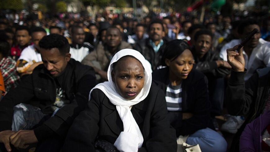 An African migrant sits with compatriots on the third day of protests against Israel's detention policy toward migrants it sees as illegal job-seekers, in Tel Aviv's Levinsky park January 7, 2014. REUTERS/Ronen Zvulun (ISRAEL - Tags: POLITICS CIVIL UNREST SOCIETY IMMIGRATION) - RTX17549