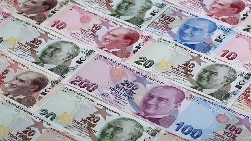 Turkish lira banknotes are seen in this photo illustration taken in Istanbul January 7, 2014. Turkey's lira slipped against the U.S. dollar on Wednesday as the government bond yield curve, which had briefly inverted on Tuesday because of speculation about an emergency rate hike to rescue the currency, returned to a positive slope. Picture taken January 7, 2014. REUTERS/Murad Sezer (TURKEY - Tags: BUSINESS) - RTX1761J