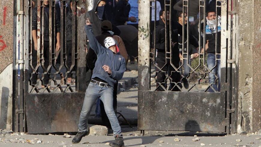 A student of Al-Azhar University, who is a supporter of the Muslim Brotherhood and deposed Egyptian President Mohamed Mursi, throws a stone during clashes with riot police and residents of the area at the university campus in Cairo's Nasr City district January 8, 2014. The trial of Mursi on charges of inciting murder of protesters was postponed on Wednesday until Feb. 1 after officials said that bad weather had prevented him being flown to court.  REUTERS/Mohamed Abd El Ghany (EGYPT - Tags: POLITICS CIVIL U
