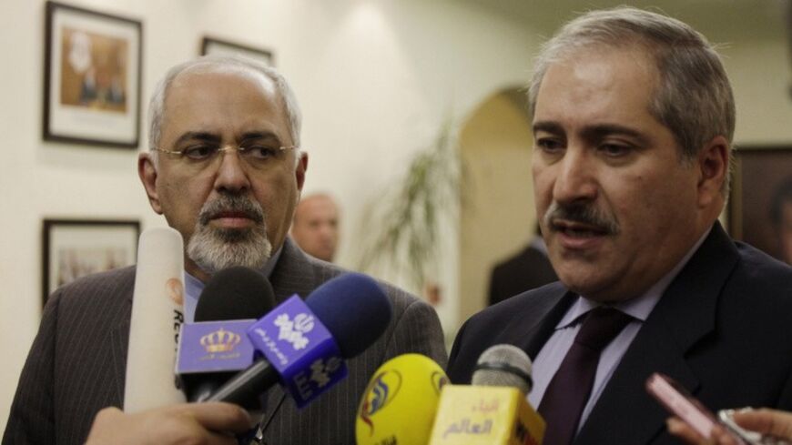Iranian Foreign Minister Mohammad Javad Zarif (L) listens to his Jordanian counterpart Nasser Judeh during a joint news conference in Amman, Jordan January 14, 2014. REUTERS/Mohammad Hannon/Pool (JORDAN - Tags: POLITICS) - RTX17E5V