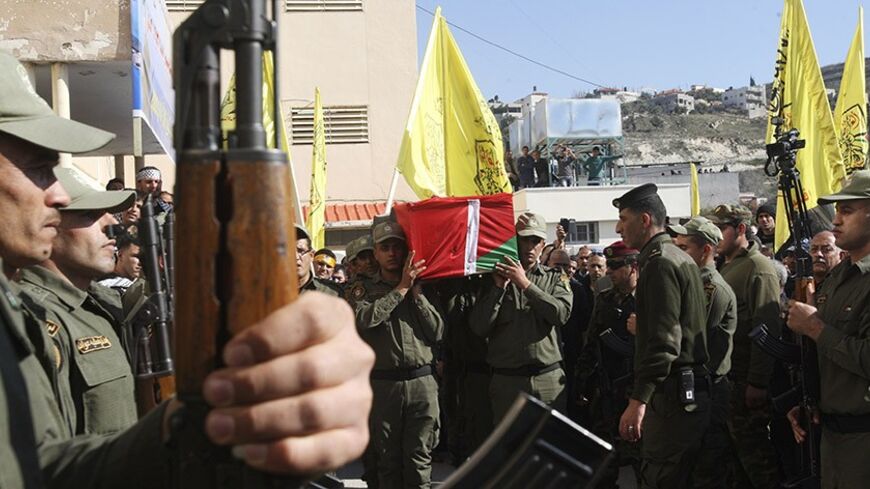 Members of the Palestinian security forces carry a coffin containing the remains of Palestinian militant Majdi Khanfar during his funeral in the West Bank village of Silat al-Daher, near Jenin, January 20, 2014. Israel has begun to exhume the remains of a number of Palestinian militants, including Khanfar, to return them to their families for burial, the army said on Sunday, a move that could help ease some tension between the adversaries. REUTERS/Abed Omar Qusini (WEST BANK - Tags: POLITICS CIVIL UNREST) -