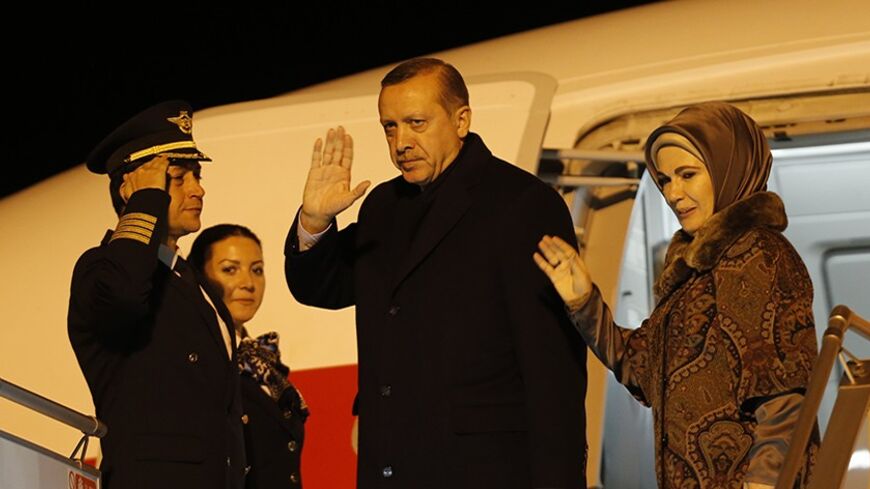 Turkish Prime Minister Tayyip Erdogan and his wife Emine Erdogan wave before their departure for Brussels at Esenboga Airport in Ankara January 20, 2014. Rocked by a corruption scandal, Turkey looks further than ever from its goal of European Union membership as Erdogan visits Brussels this week in the midst of a crackdown on the judiciary and police. Erdogan has purged hundreds of police and sought tighter control of the courts since a corruption inquiry burst into the open last month, a scandal he has cas