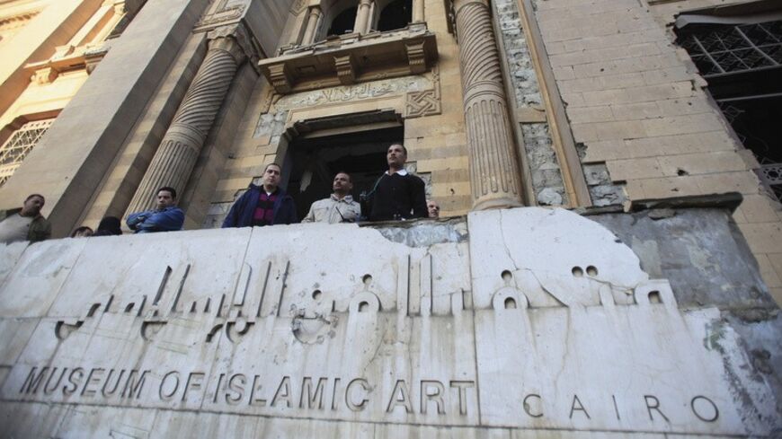 Police officers and people gather in front of the damaged Museum of Islamic Art building, after a bomb blast occurred at the nearby Cairo Security Directorate, which includes police and state security, in downtown Cairo, January 24, 2014. A suicide bomber in a car blew himself up in the parking lot of a top security compound in central Cairo on Friday, killing at least four people in one of the most high-profile attacks on the state in months, security sources said. REUTERS/Amr Abdallah Dalsh  (EGYPT - Tags