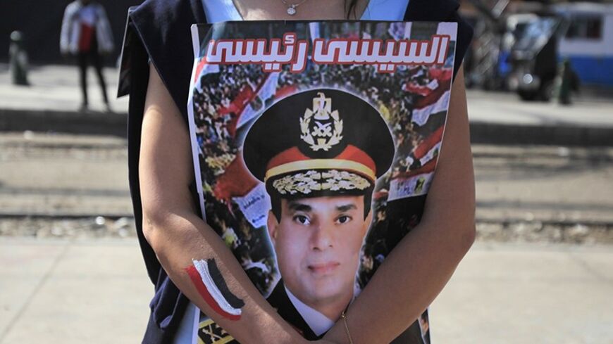 A supporter of Egypt's army chief General Abdel Fatah al-Sisi hugs his poster during celebrations of the third anniversary of Egypt's uprising, in front of El-Thadiya presidential palace in Cairo January 25, 2014. Egyptian police fired live rounds in the air to disperse about 1,000 anti-government protesters in central Cairo on Saturday, a Reuters witness said, amid fears of violence on the anniversary of the 2011 revolt that ousted autocrat Hosni Mubarak. The poster reads "al-Sisi is my president." REUTERS