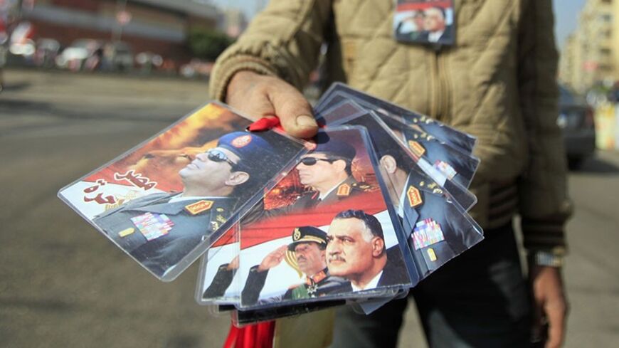 A street vendor shows signs of Egypt's army chief General Abdel Fatah al-Sisi during celebrations of the third anniversary of Egypt's uprising in front of El-Thadiya presidential palace in Cairo January 25, 2014. Egyptian police fired live rounds in the air to disperse about 1,000 anti-government protesters in central Cairo on Saturday, a Reuters witness said, amid fears of violence on the anniversary of the 2011 revolt that ousted autocrat Hosni Mubarak. REUTERS/Amr Abdallah Dalsh  (EGYPT - Tags: POLITICS 