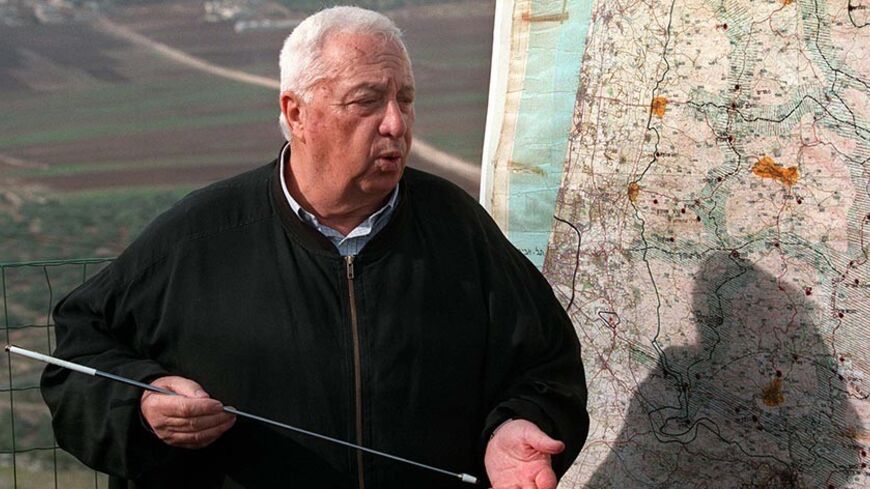 National Infrastructure Minister Ariel Sharon maps out December 5 his vision of an Israeli security zone stretching deep into the West Bank on land Palestinians see as part of a future state. Sharon spoke while leading members of the Foreign Press Association on a tour of West Bank Jewish settlements. - RTXH39C