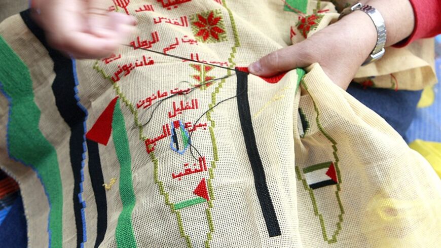 A Palestinian woman embroiders a map of Palestine to mark the 61st anniversary of Nakba at the Burj al-Barajneh refugee camp in Beirut May 15, 2009. Palestinians mark Nakba as a day of mourning for the establishment of Israel in 1948 after which an Arab-Israeli war brought the displacement of hundreds of thousands of Palestinians. REUTERS/Jamal Saidi   (LEBANON ANNIVERSARY POLITICS) - RTXH51I