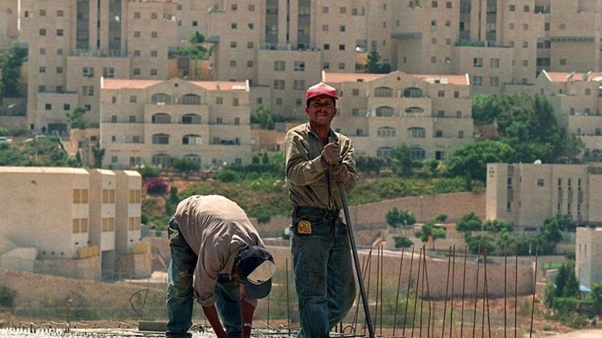 Palestinian workers build houses for Jewish settlers in the West Bank settlement of Ma'ale Adumim July 26. Building on Jewish settlements in the West Bank and Gaza Strip more than doubled in the first quarter of this year, Israeli Radio said on Sunday. - RTXI53F
