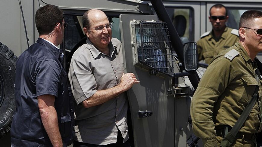 Israeli Defense Minister Moshe Yaalon (2nd L) gets out of a military jeep during a visit to an army base near Kibbutz Kissufim outside the central Gaza Strip May 7, 2013. Israel played down weekend air strikes close to Damascus reported to have killed dozens of Syrian soldiers, saying they were not aimed at influencing its neighbour's civil war but only at stopping Iranian missiles reaching Lebanese Hezbollah militants. REUTERS/Amir Cohen (ISRAEL - Tags: MILITARY POLITICS) - RTXZDJS