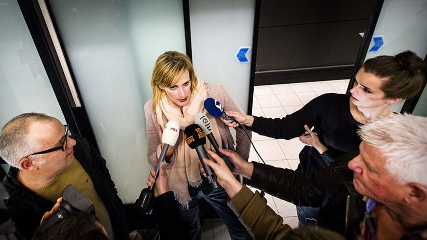 Dutch journalist Rena Netjes holds a press point on February 4, 2014 as she arrives at Schiphol Airport, the Netherlands, after being accused by Egypt of being part of a "terror cell" involving Qatari-owned broadcaster Al-Jazeera. Netjes flew out of Cairo early February 4 after several days in hiding, following a crackdown on the pan-Arab satellite broadcaster which Cairo accuses of backing the Muslim Brotherhood ousted from power by the military in July. AFP PHOTO / ANP / REMKO DE WAAL -- The Netherlands o