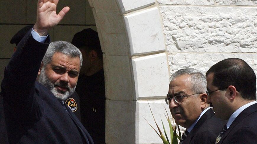 GAZA CITY, -: Palestinian Prime Minister Ismail Haniya, new Finance Minister Salam Fayad (2R) and new Sports and Youth Minister Bassem Naim (R) arrive for the first meeting of the new Palestinian unity cabinet in Gaza City, 18 March 2007. The new Palestinian government held its first cabinet meeting today, vowing to confront rampant lawlessness and end a crippling international aid freeze but facing a continued Israeli boycott. AFP PHOTO/MAHMUD HAMS (Photo credit should read MAHMUD HAMS/AFP/Getty Images)