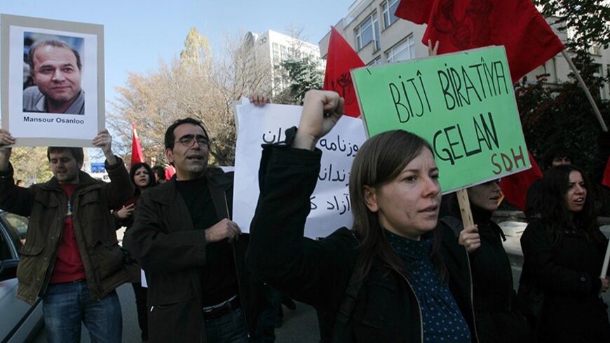 A protestor holds a portrait of Iranian trade-union activist Mansour Osanloo during a demonstration against the Iranian governement in front of the Iranian embassy in Ankara on November 21, 2009. Mansour Osanloo is  reportedly serving a prison sentence in Iran. AFP PHOTO / ADEM ALTAN (Photo credit should read ADEM ALTAN/AFP/Getty Images)