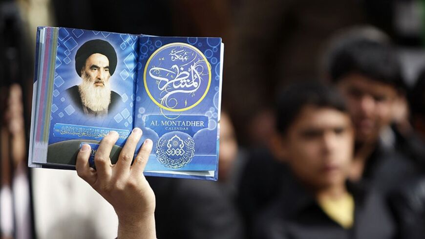 An Iraqi man holds a picture of top Shiite cleric Grand Ayatollah Ali Husseini al-Sistani at a campaign rally for Ammar al-Hakim, head of the Supreme Islamic Iraqi Council (SIIC), which is part of the broad Shiite coalition the Iraqi National Alliance, in Baghdad March 5, 2010. Politicians launched into their last day of campaigning as more than a million Iraqis living abroad began voting in an election that could turn the page on years of deadly sectarian strife. AFP PHOTO/AHMAD AL-RUBAYE (Photo credit sho