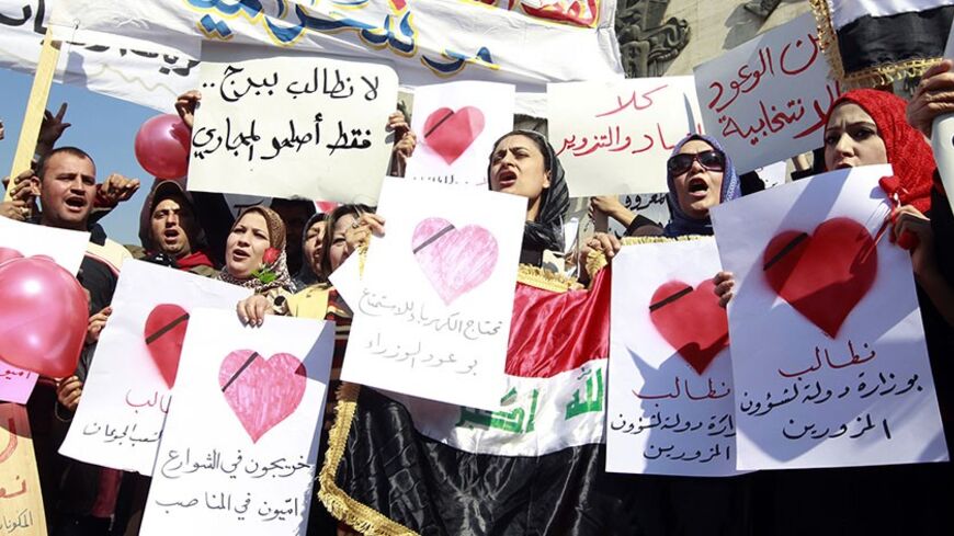 Women demonstrate against the lack of basic services in central Baghdad on Valentine's Day February 14, 2011. About 100 residents carried placards and chanted slogans demanding better basic services and a stop to corruption in the country. The placards read "Do not erect a tower, just fix the sewage" and "We need electricity power, not ministers' promises".   REUTERS/Thaier al-Sudani (IRAQ - Tags: CIVIL UNREST POLITICS) - RTR2IKXM