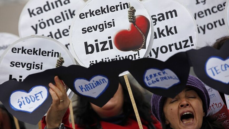 Women holding a sign which reads: "Men's love is killing us" (C), shout slogans during a protest on Valentine's Day in Istanbul February 14, 2012. A group of female supporters of the left wing Socialist Platform of the Oppressed (ESP), gathered in central Istanbul to protest against Valentine's Day and draw attention to what they said were rising incidences of domestic violence in Turkey. REUTERS/Murad Sezer (TURKEY - Tags: POLITICS CIVIL UNREST) - RTR2XU78