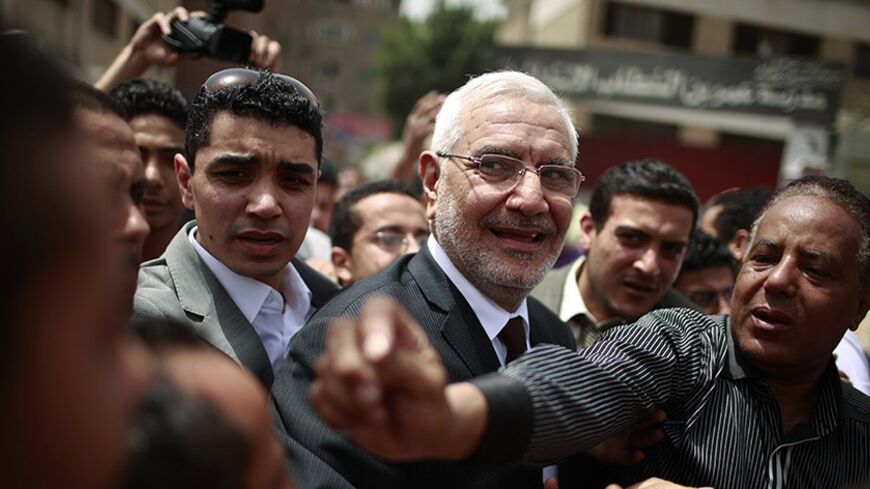 Presidential candidate Abdel Moneim Abol Fotouh (C) visits people outside a polling station during the presidential elections in Cairo May 23, 2012. Egyptians relished their first free leadership vote on Wednesday, with Islamists pitted against secular figures in a contest unthinkable before a popular revolt swept President Hosni Mubarak from power 15 months ago. REUTERS/Suhaib Salem (EGYPT - Tags: POLITICS ELECTIONS) - RTR32INP