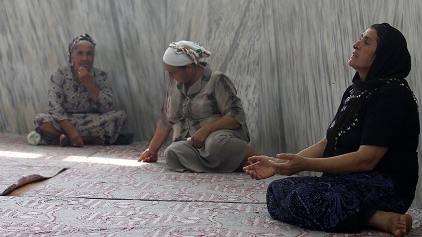 Turkish Alawite women pray in a tomb, a holy site to the Alawite community, in the Samandag district of Hatay province, close to the border with Syria, July 27, 2012. An influx of Syrians fleeing President Bashar al-Assad's military onslaught is stoking tension in the area of Turkey known for religious tolerance and setting Turks who share the Syrian leader's creed against their own government. In the Turkish frontier province of Hatay, home to the Antioch of the Bible and a mix of confessional groups rare 