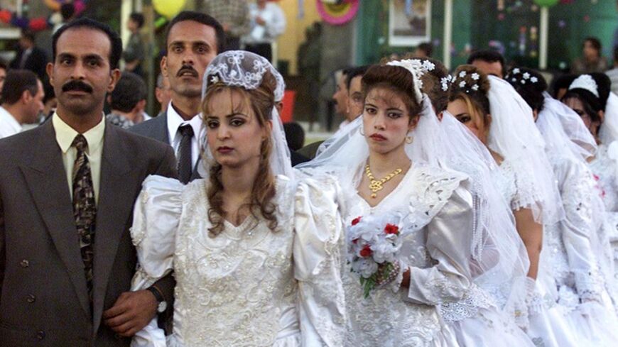 A mass wedding organised by the government takes place in Baghdad
October 15, 2001. Many Iraqis opt for a mass marriage due to economic
restrictions. REUTERS/ Faleh Kheiber REUTERS

FK/FMS - RTRO628