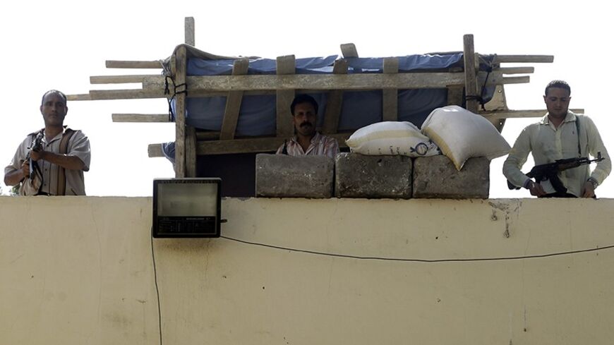 Plainclothes policemen hold their weapons as they stand guard on the roof of the Boulaq Al-Dakrour police station, after an explosion in Giza, south of Cairo, September 2, 2013. An improvised bomb exploded at a police station in downtown Cairo on Monday, wounding two workers, the state news agency said. MENA said three people on a motorcycle hurled what it called a homemade hand grenade at the police station. There was no immediate claim of responsibility. REUTERS/Amr Abdallah Dalsh  (EGYPT - Tags: POLITICS