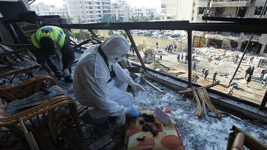A forensic inspector collects evidence at the site of the two suicide bombings that occurred on Tuesday near Iran's embassy compound in Beirut November 20, 2013. Two suicide bombings rocked Iran's embassy compound in Lebanon on Tuesday, killing at least 23 people including an Iranian cultural attache and hurling bodies and burning wreckage across a debris-strewn street. REUTERS/Sharif Karim (LEBANON - Tags: POLITICS CIVIL UNREST) - RTX15LJV